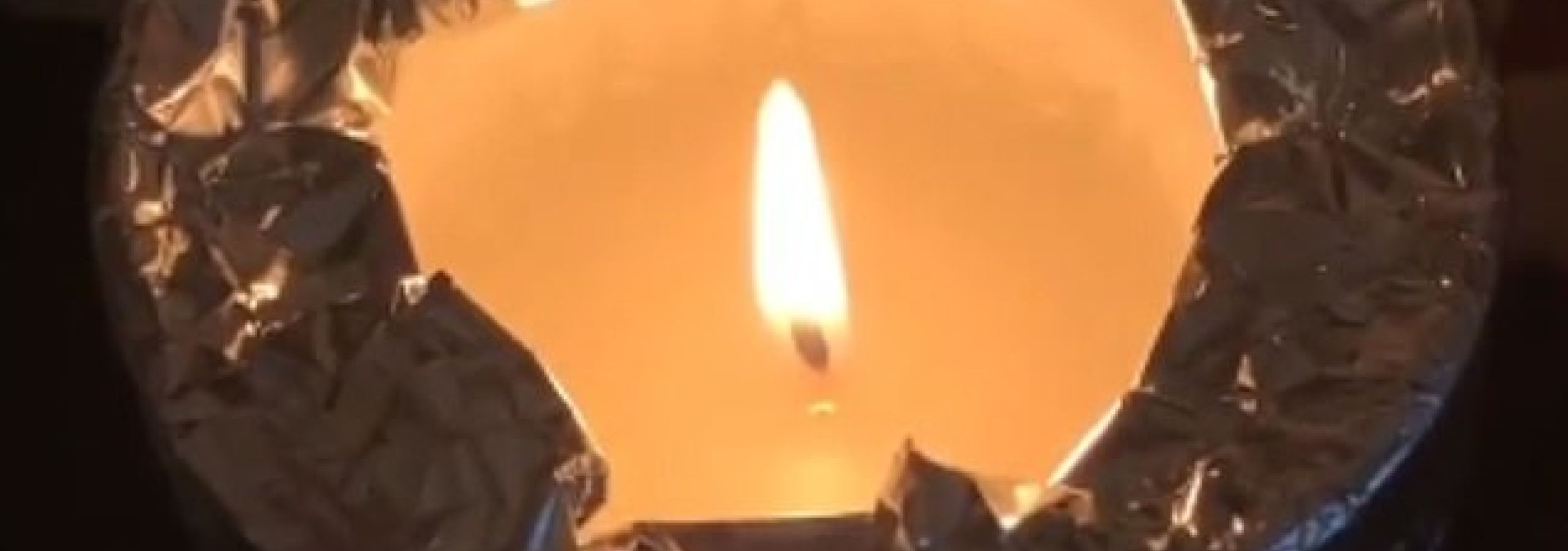 lit candle with aluminium foil around it
